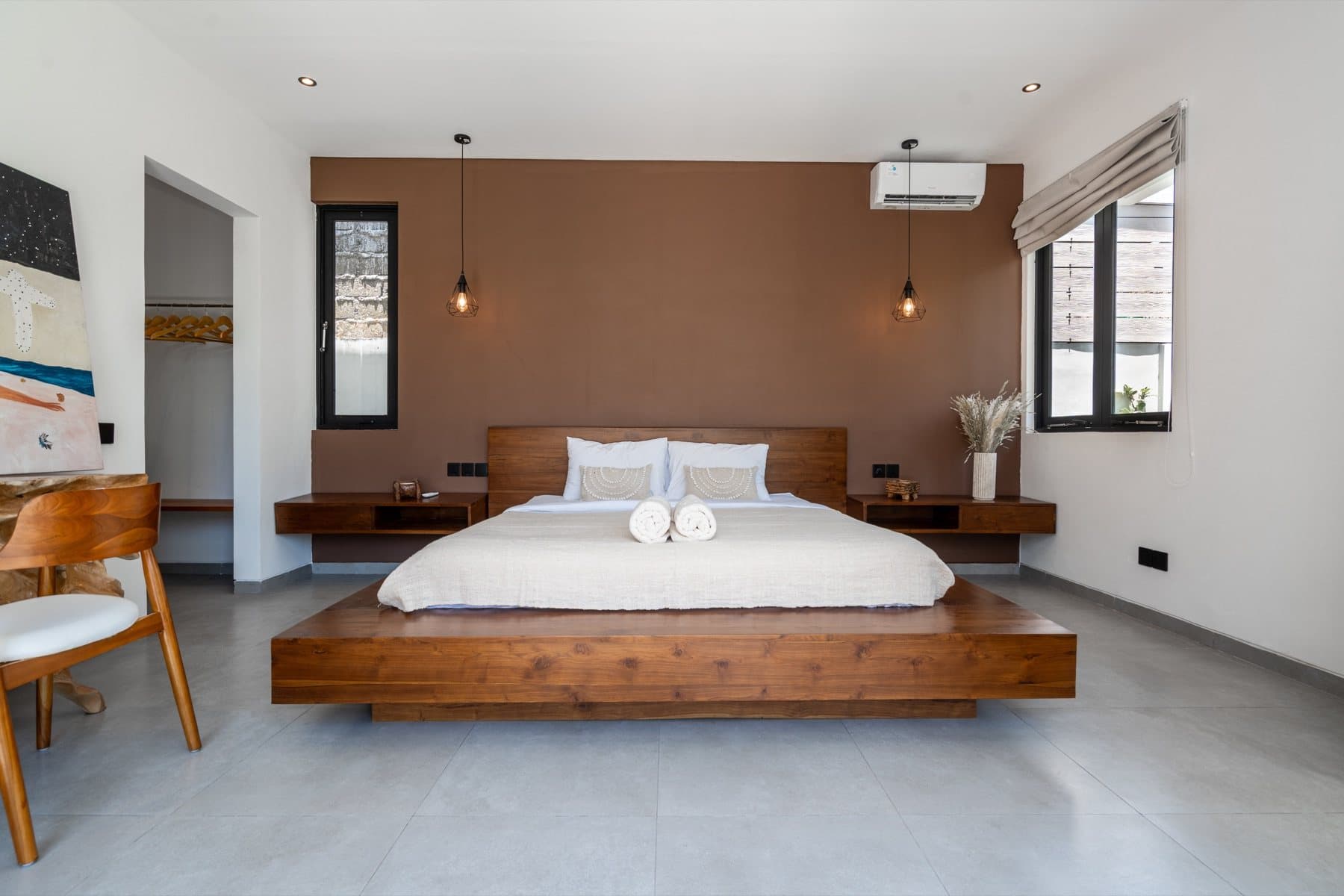 Completed bedroom with a wooden bed, bedside units and a warm accent wall