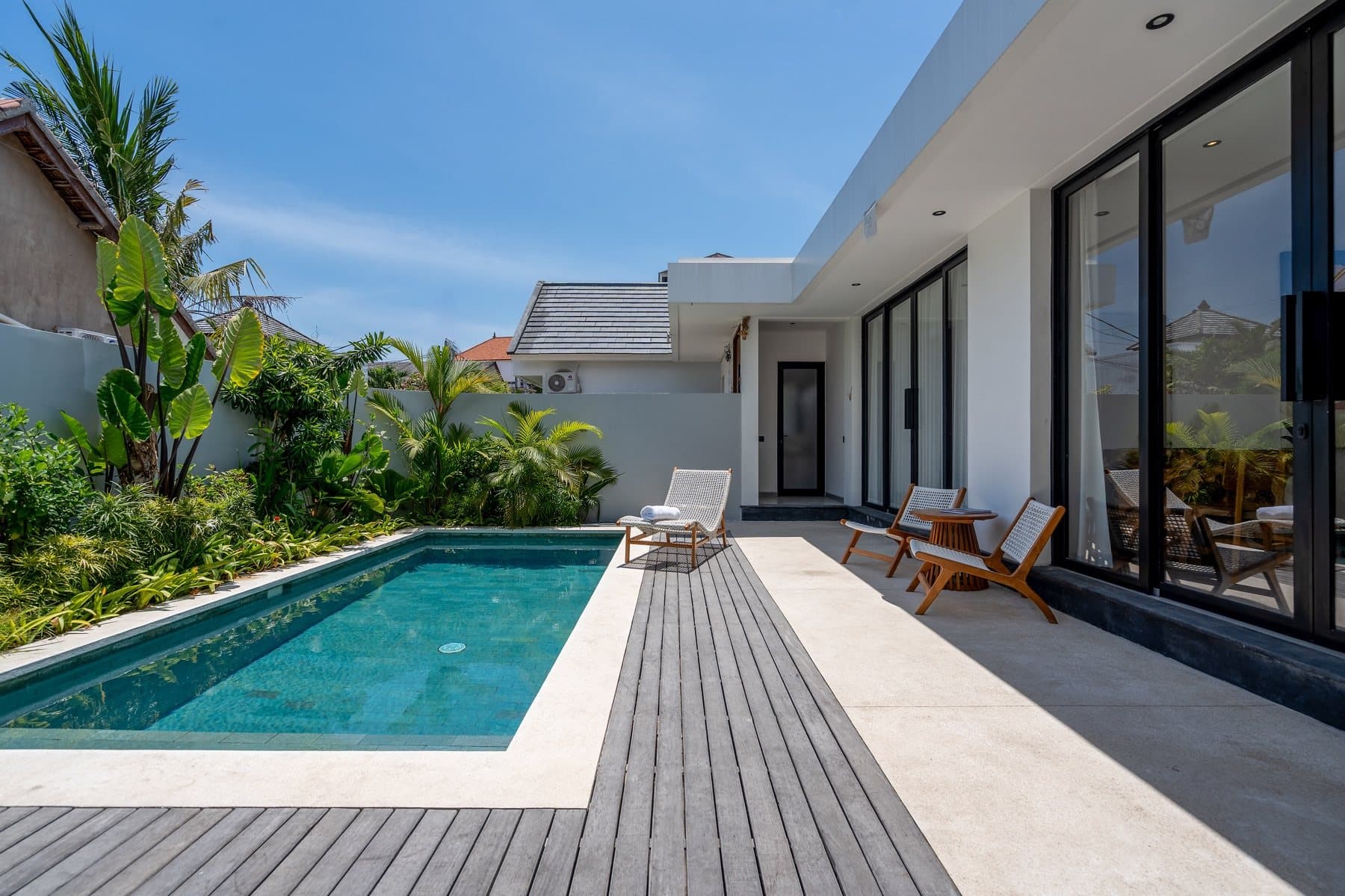 Villa pool with terrace seating and tropical planting