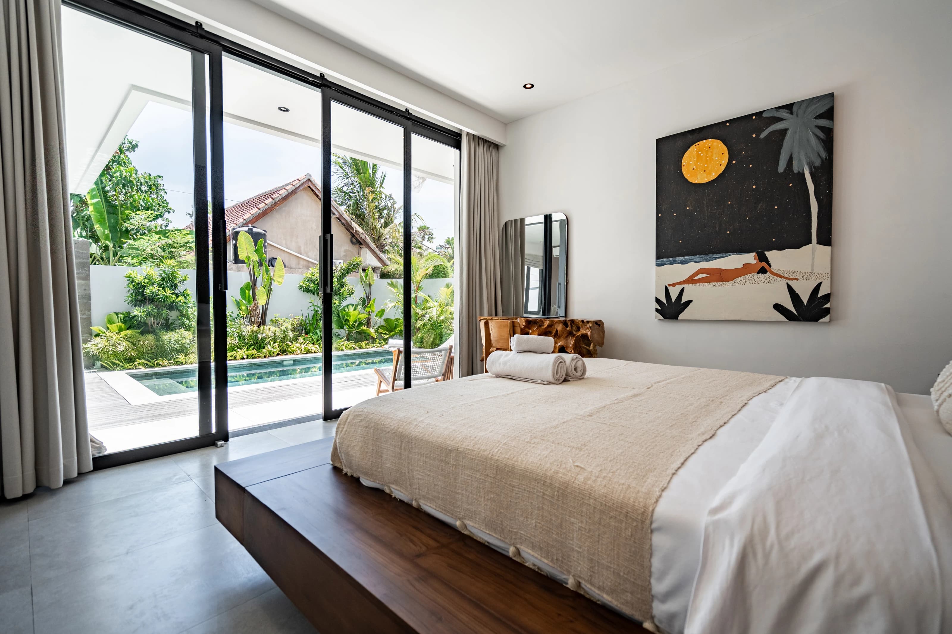 Bali villa bedroom with a wooden bed and a panoramic pool view